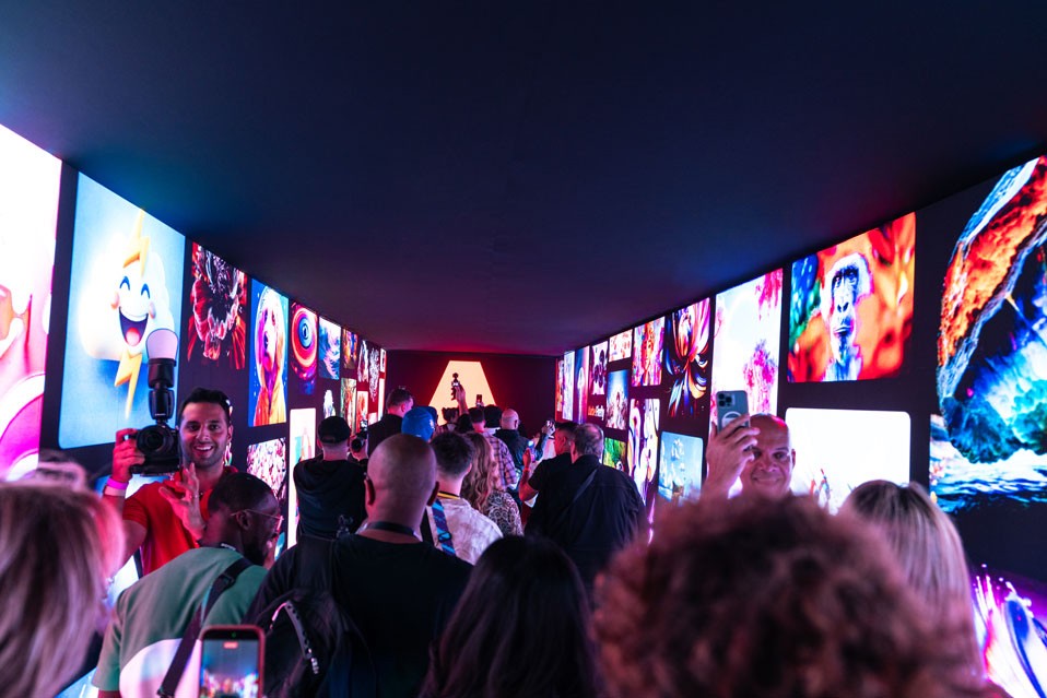 Guests walking through a corridor of illuminated screens at an event